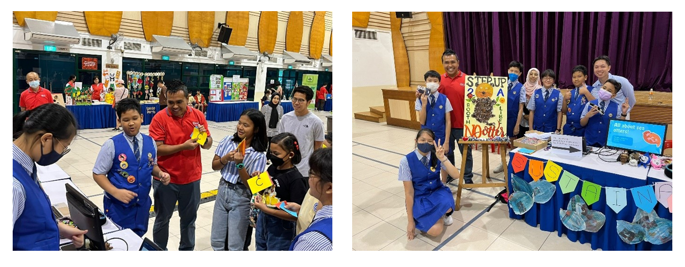 Students presenting their sustainability projects and posing at their exhibition booth during a community sustainability event.